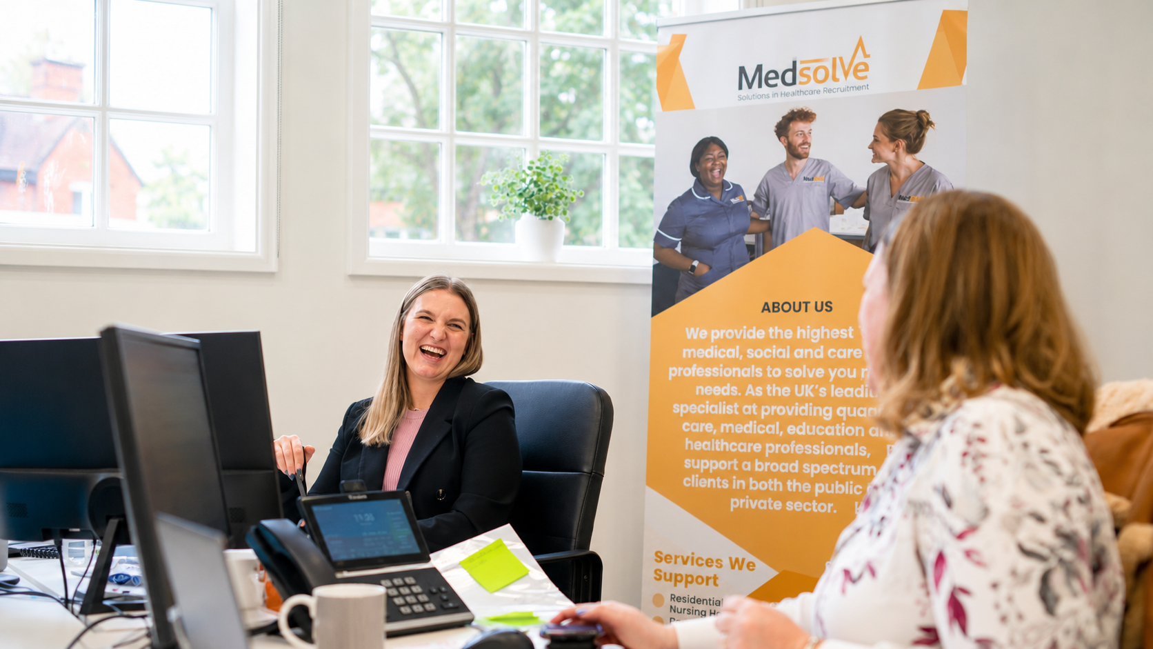 Medsolve consultant having a friendly conversation with a healthcare candidate in a bright office setting.